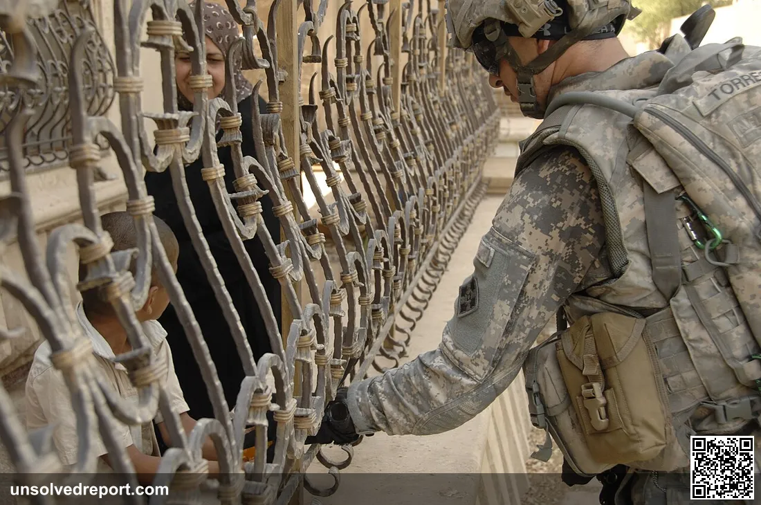 U.S. Army Sgt. 1st Class Frankie Torres, a native of Passaic, N.J., hands candy to a local child while on patrol in Bag…